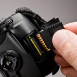 inserting a memory card into a modern DSLR camera